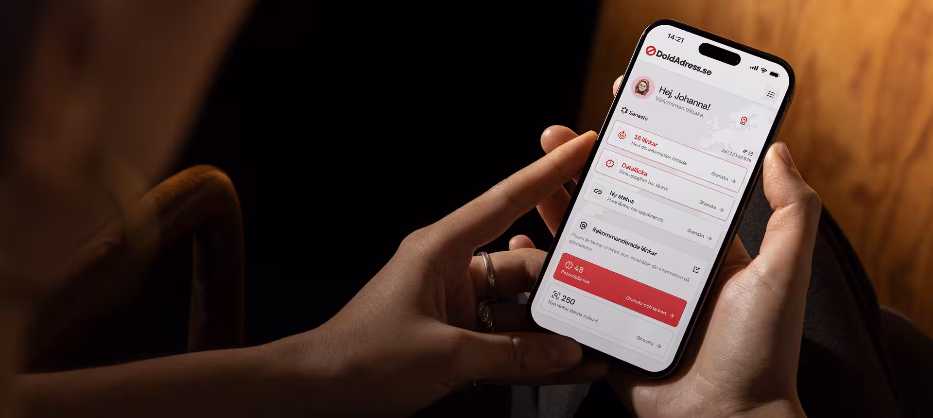 Användare håller i mobilen med DoldAdress.se:s dashboard öppen, där det visas information om dataläckor, hittade länkar och potentiella hot mot personuppgifter.