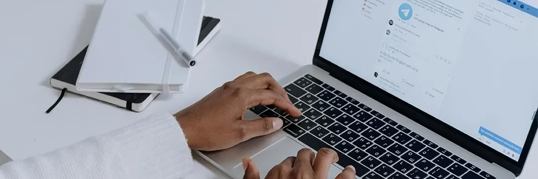 Person använder laptop med öppet chattfönster – illustrerar processen för att upptäcka och återställa ett kapat Facebook-konto.